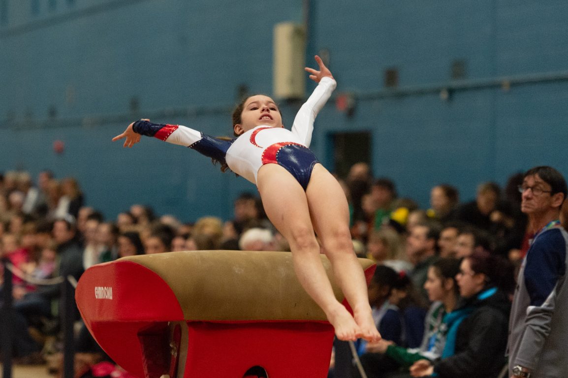 gymnast leaping over obstacle