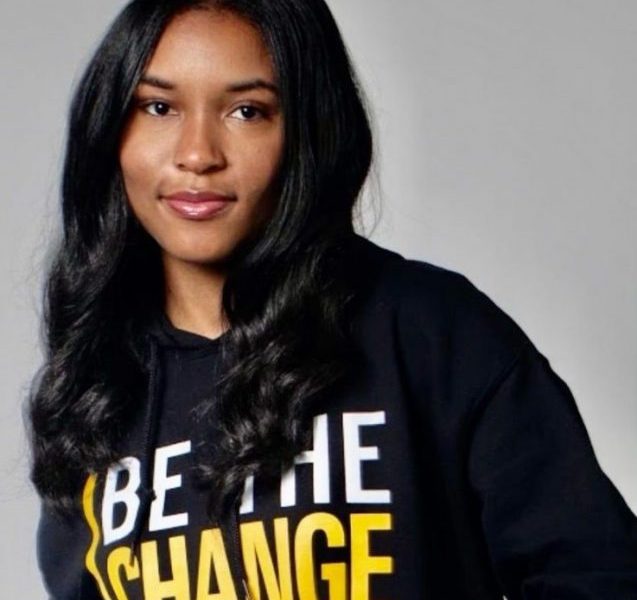 Jordyn Hudson poses wearing a sweatshirt that reads "be the change."
