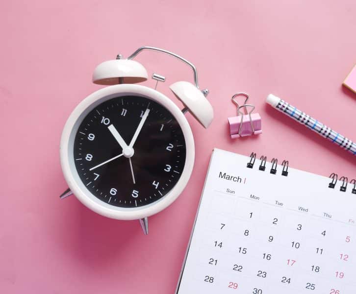 Time-keeping objects on a pink backdrop