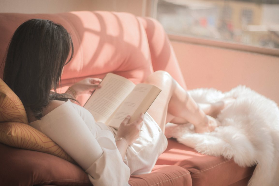 A woman reads on her couch