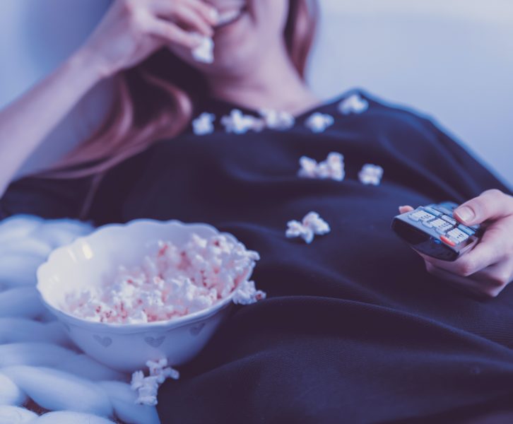 Woman eating popcorn and watching tv
