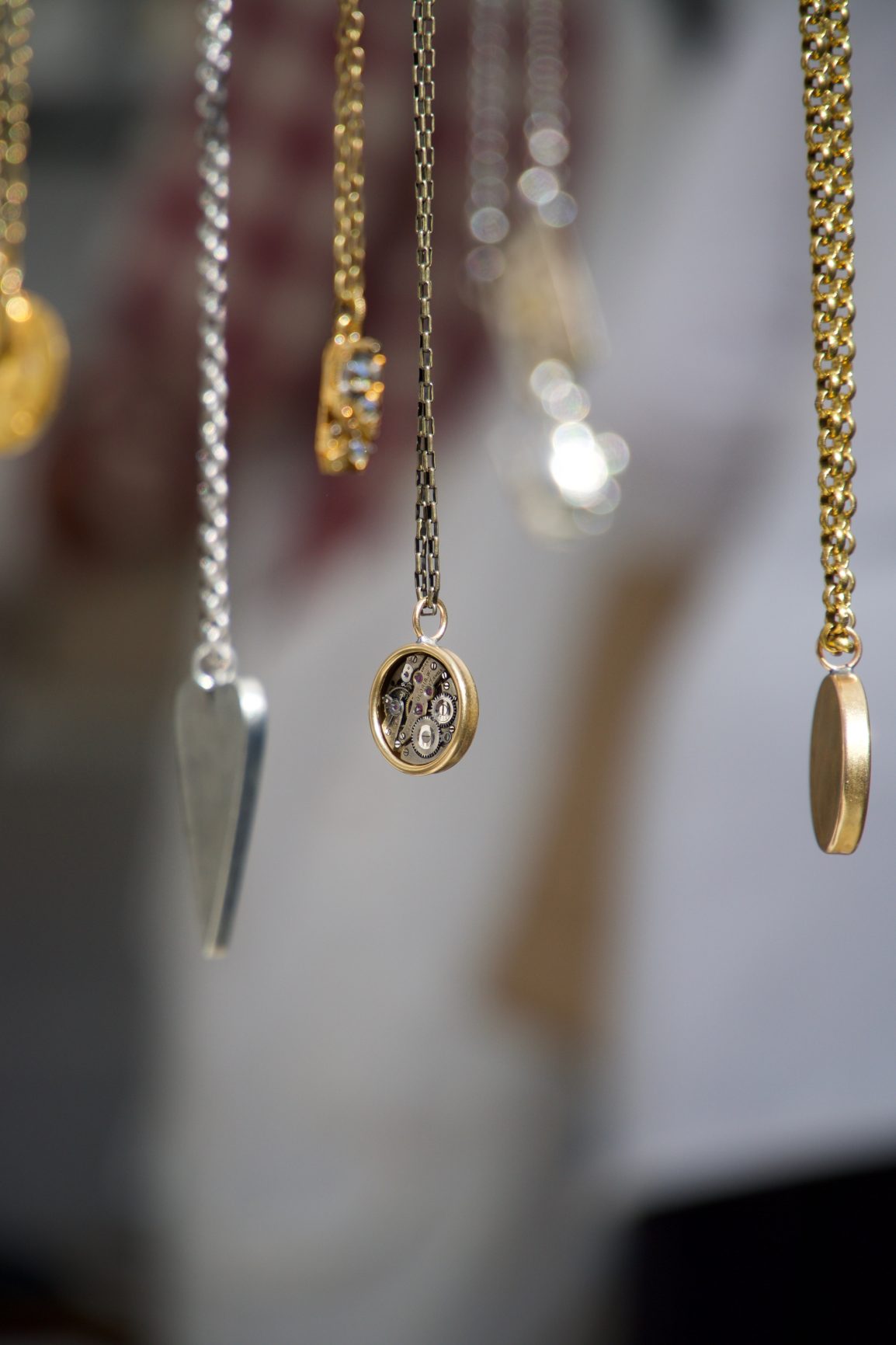 various colored and styles of necklaces hanging in a row